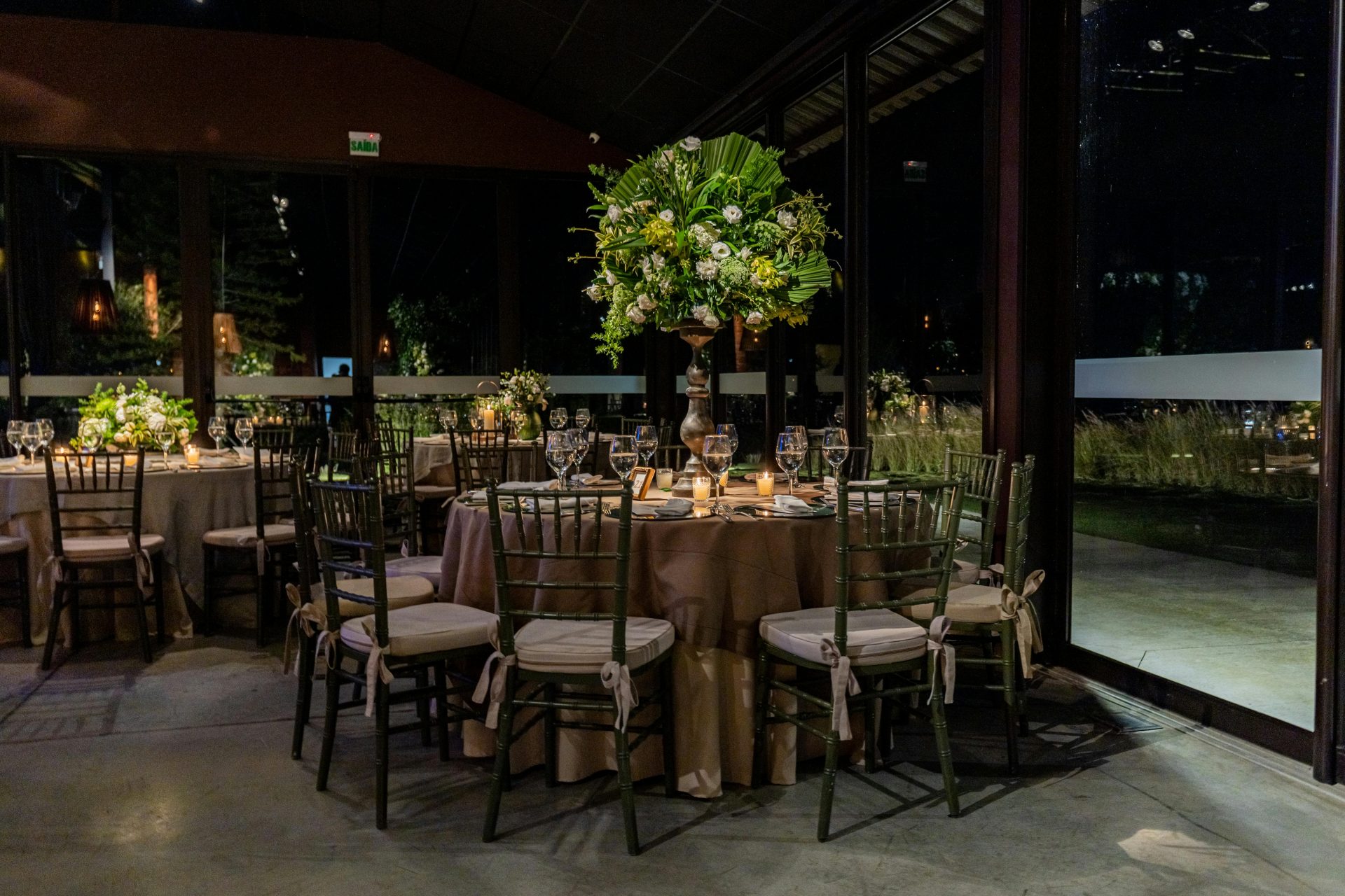 Luxurious indoor dining scene with floral decorations and elegant table settings.